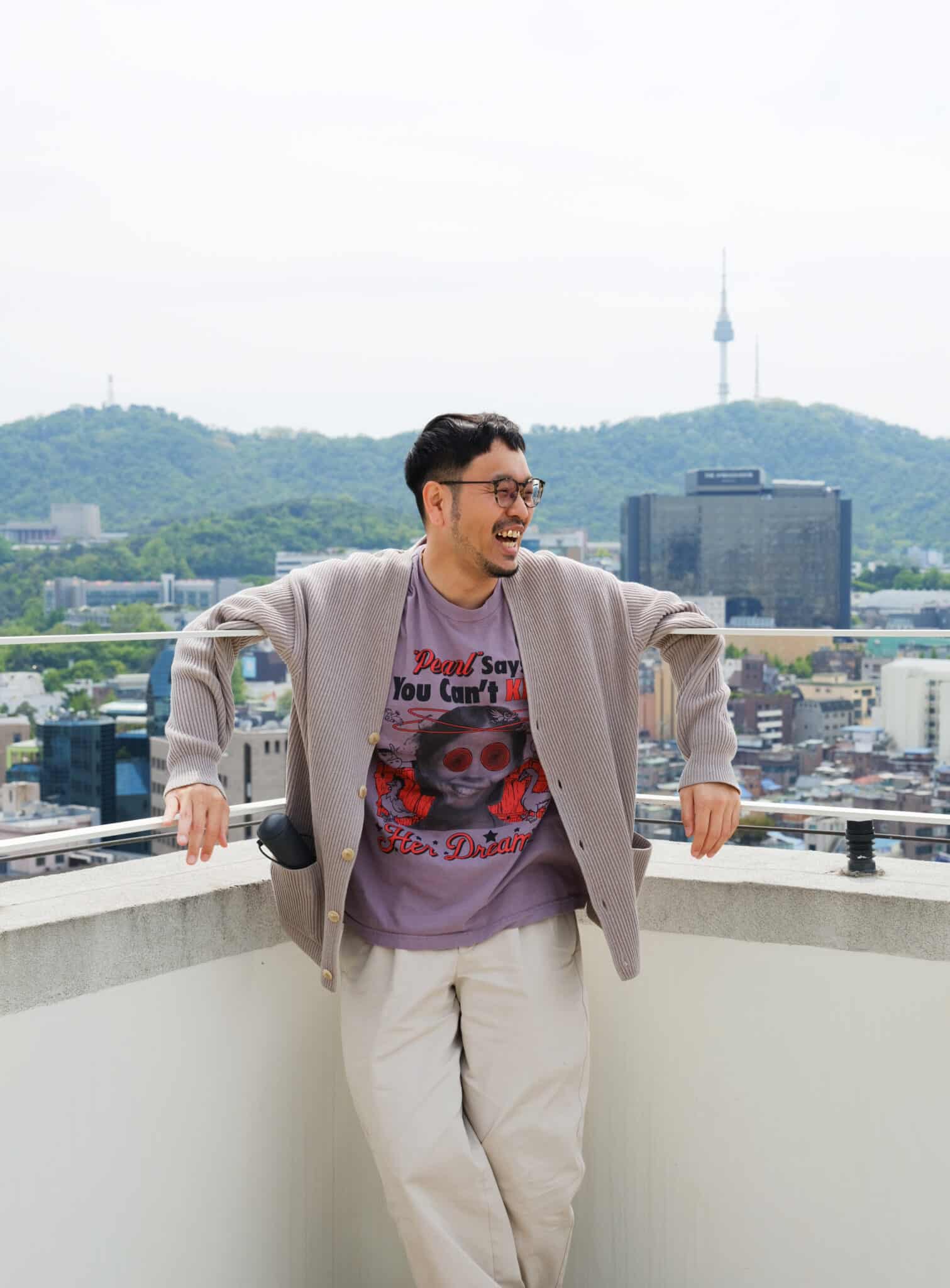 베란다 난간에 기대있는 선글라스 쓴 남자